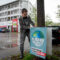 Andreas Wagner befestigt ein Plakat mit der Aufschrift "Klima vor Profit"
