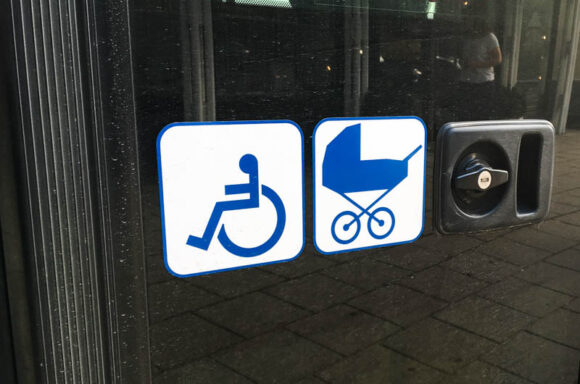 Piktogramm von Rollstuhl und Kinderwagen an der Türe eines Linienbus